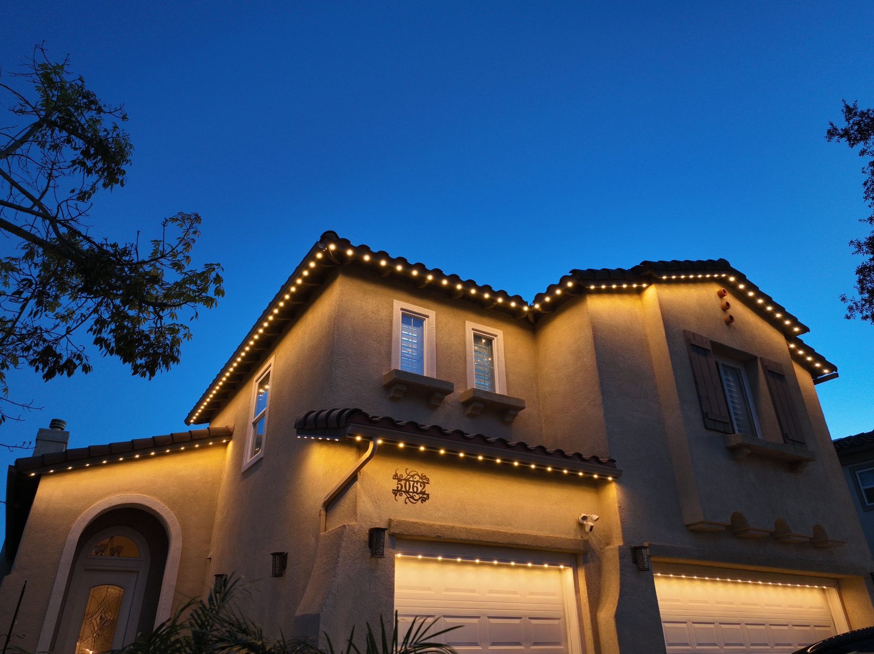 Tile-roof home, warm lights at blue hour